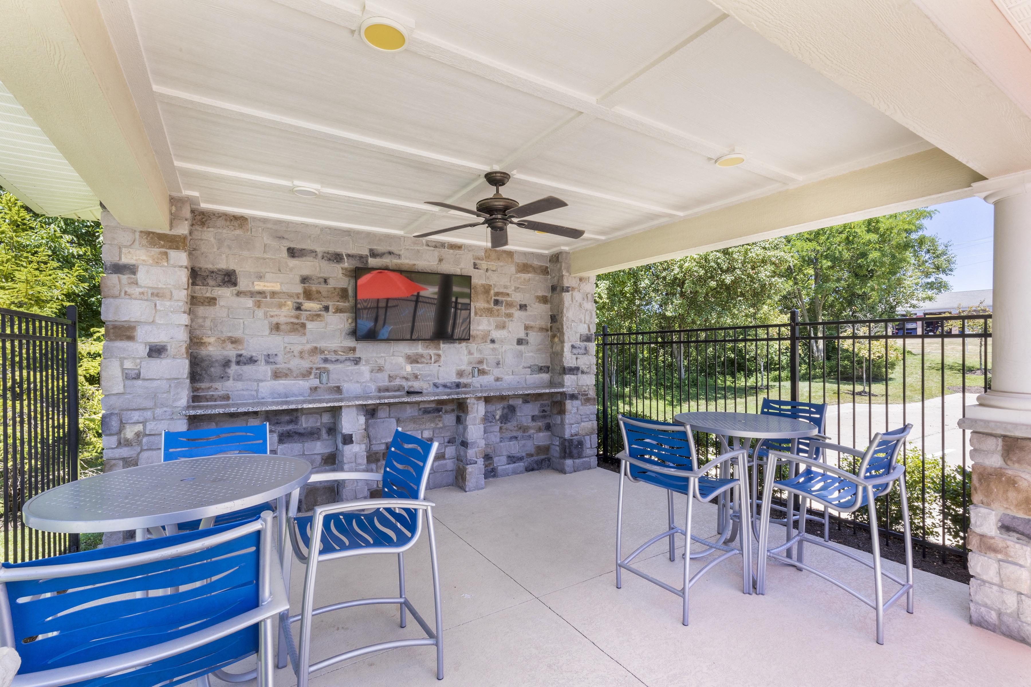 a patio with tables and chairs and a tv on the wall at Aventura at Towne Centre, Missouri, 63011